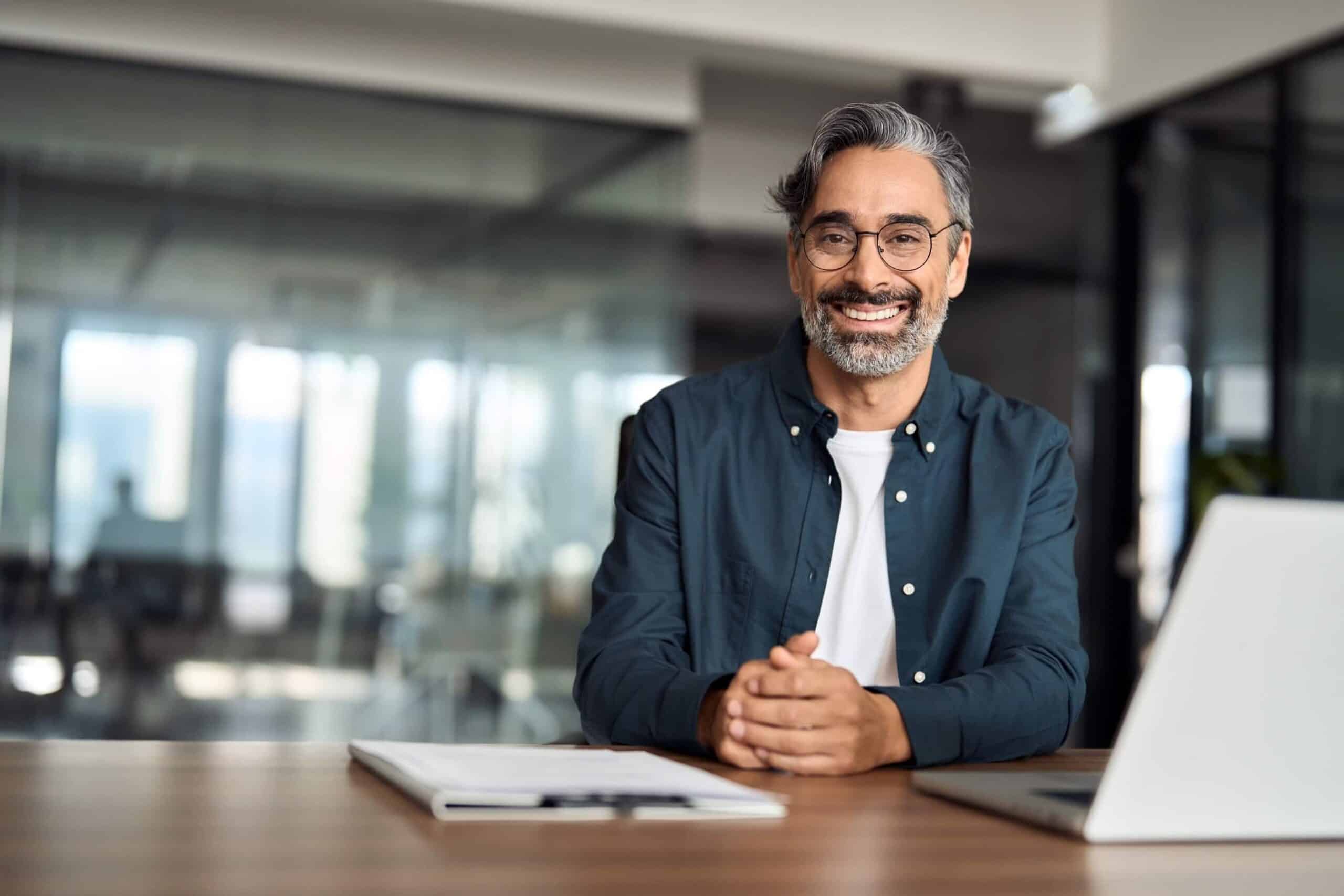 Man wearing prescription glasses at his desk